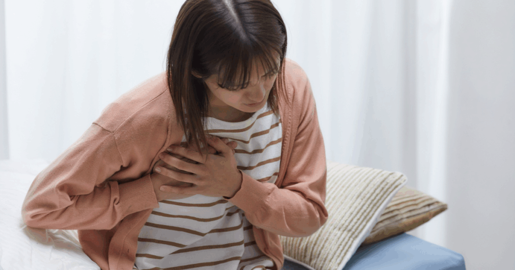 an image of a woman with chest pain for an article on the implications that delayed blood tests can have on patients with serious conditions' health